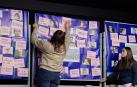 Dos alumnas de Larraona colocan mensajes junto a fotos de víctimas en el mural