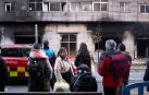 Vecinos y curiosos observan los efectos del fuego en el edificio tras el incendio de un bazar en la Rochapea