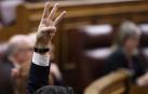 Un diputado del PSOE señala el sentido del voto de la formación durante un pleno que el Congreso celebró este jueves