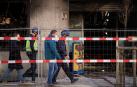 Agentes de la Policía Nacional, que investigarán lo ocurrido, ayer junto a los restos del bazar incendiado