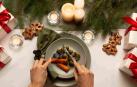 Una mesa de Navidad con un plato de zanahorias y coles de Bruselas