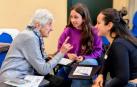Una participante en el taller intergeneracional conversa con dos estudiantes de Psicología en la UPNA.