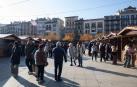 Varias personas paseando entre los puestos de la Feria de Navidad de Pamplona instalada en la plaza del Castillo