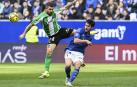 El defensa del Oviedo Lucas Ahijado despeja el balón ante la presión del bético Aitor Ruibal