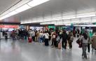 Decenas de personas haciendo cola en oficinas de alquiler de coches, en la estación Madrid-Puerta de Atocha-Almudena Grandes