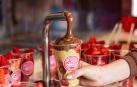 Una imagen de la preparación de un vaso de fresas bañadas en chocolate en La Fesería