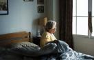 Una anciana sentada en su cama