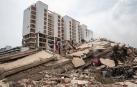 Personas caminan por los escombros de edificios afectados por los terremotos que se han producido este jueves, en La Guaira (Venezuela)