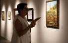 Una visitante de la muestra recién inaugurada contempla el cuadro de la plaza de San Juan de Estella durante sus fiestas