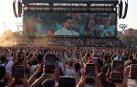 Miles de personas enfocan con sus móviles a Bad Bunny en el comienzo de su concierto en Milán que tuvo que ser anulado por un fuerte temporal de lluvia y granizo