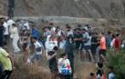 Imagen de personas escapando este jueves de las fuerzas antidisturbios marroquies que han desalojado a las masas que se encontraban cerca de la frontera con Ceuta.