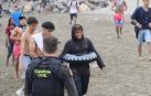 Un grupo de inmigrantes en la playa junto al paso fronterizo del Tarajal en Ceuta este viernes,