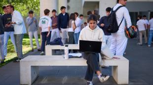 Una joven utiliza su ordenador en el campus de la Universidad de Navarra