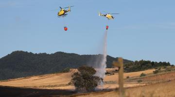 Dos helicópteros trabajando sobre un incendio declarado en un campo de cereal de Badostain